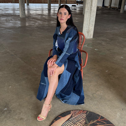 Woman sitting on a chair wearing a blue denim outfit in an indoor setting.