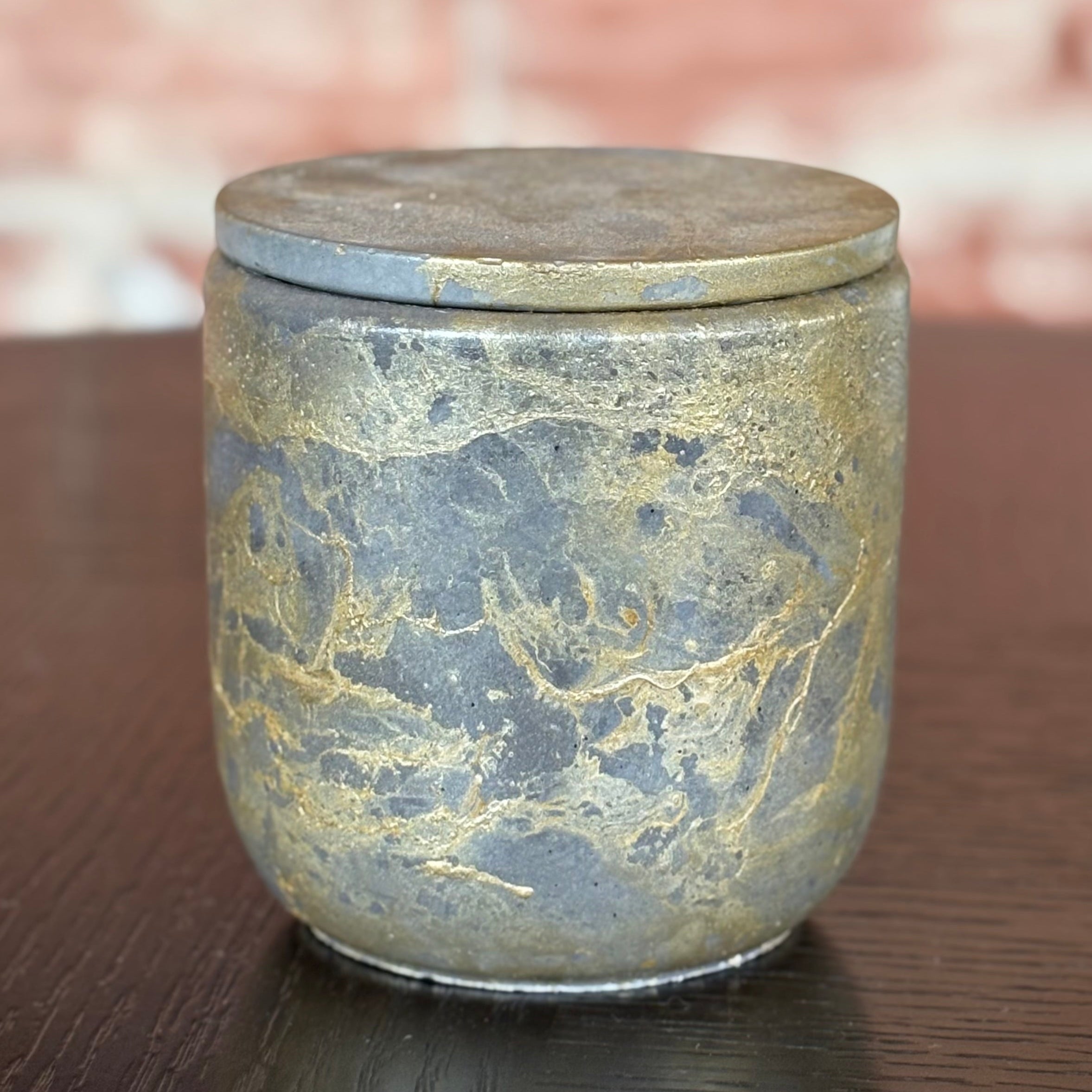 Marble-patterned ceramic jar with lid on a wooden surface